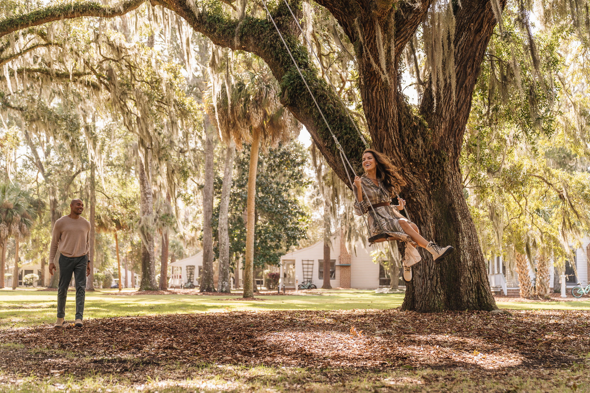 Couple on swing under oak trees