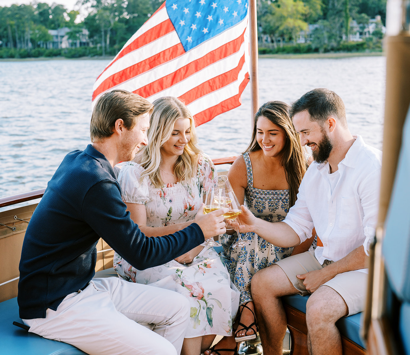 couples drinking wine on The Grace with American flag in the background