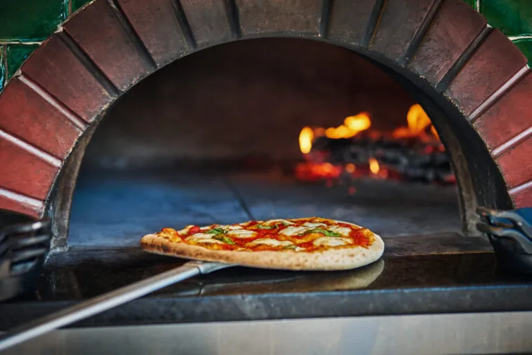 Pizza being taken out of wood-fired brick over at FLAME
