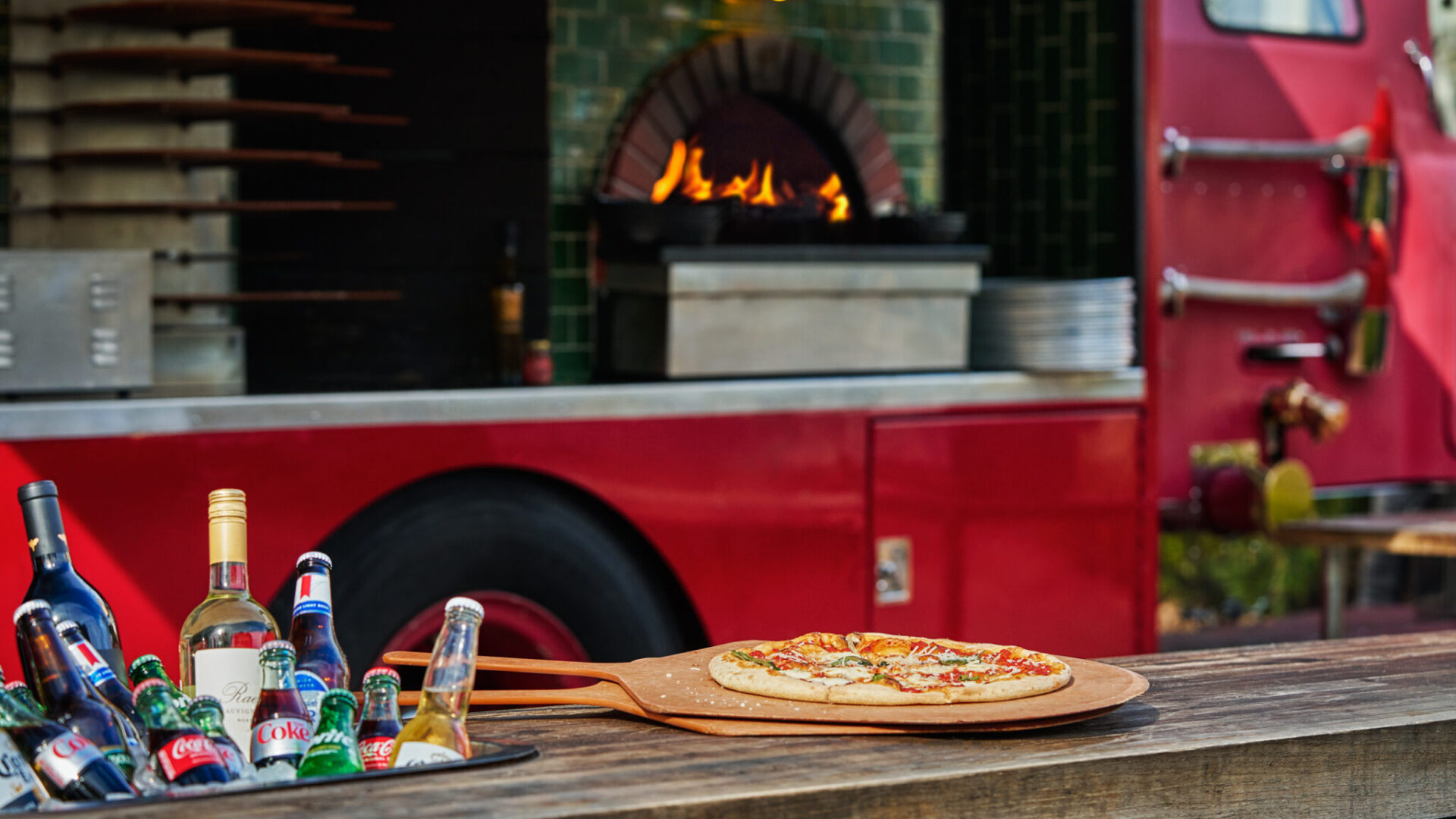 Pizza and drinks on a bar in front of FLAME