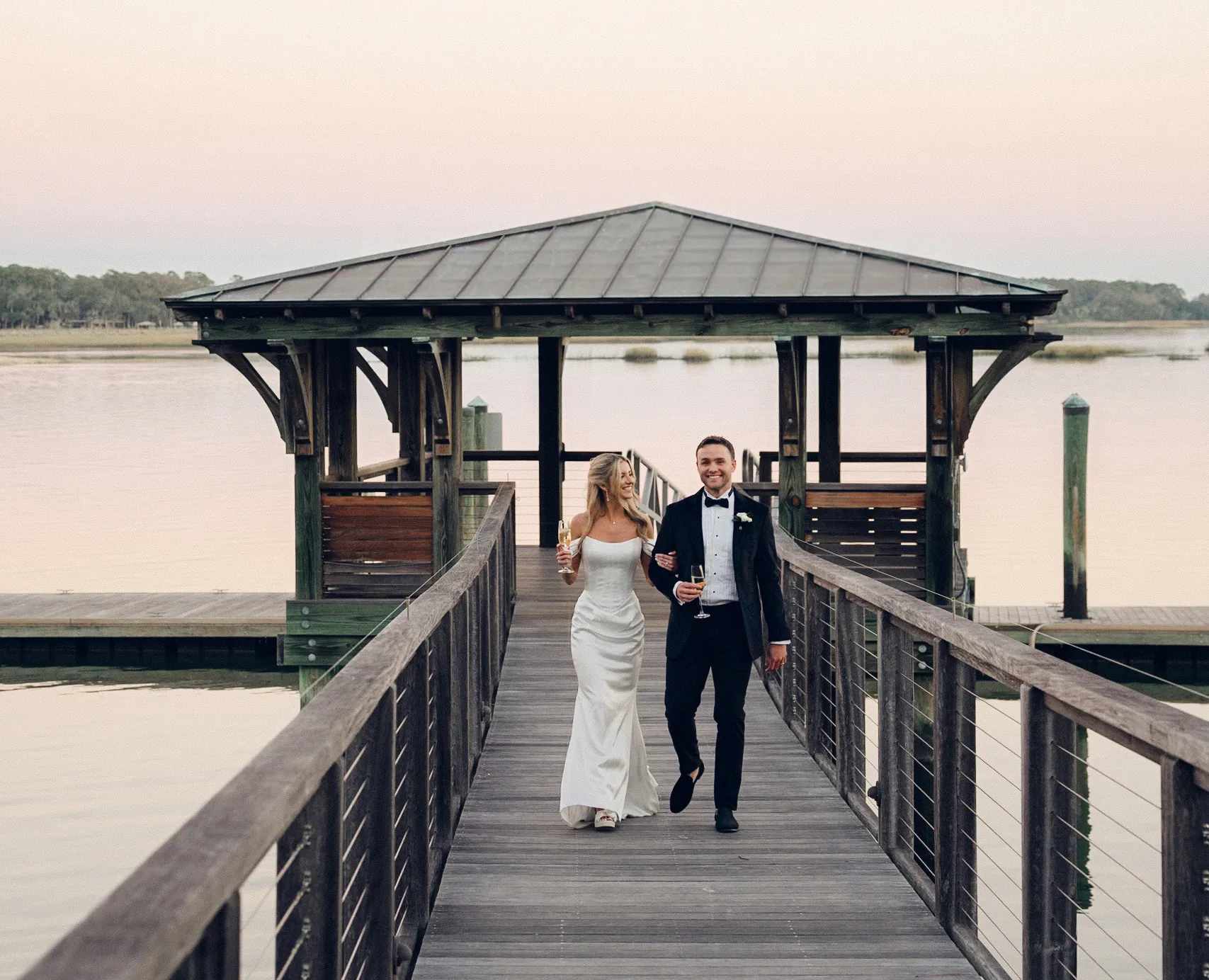 bride & Groom walking down dock after wedding